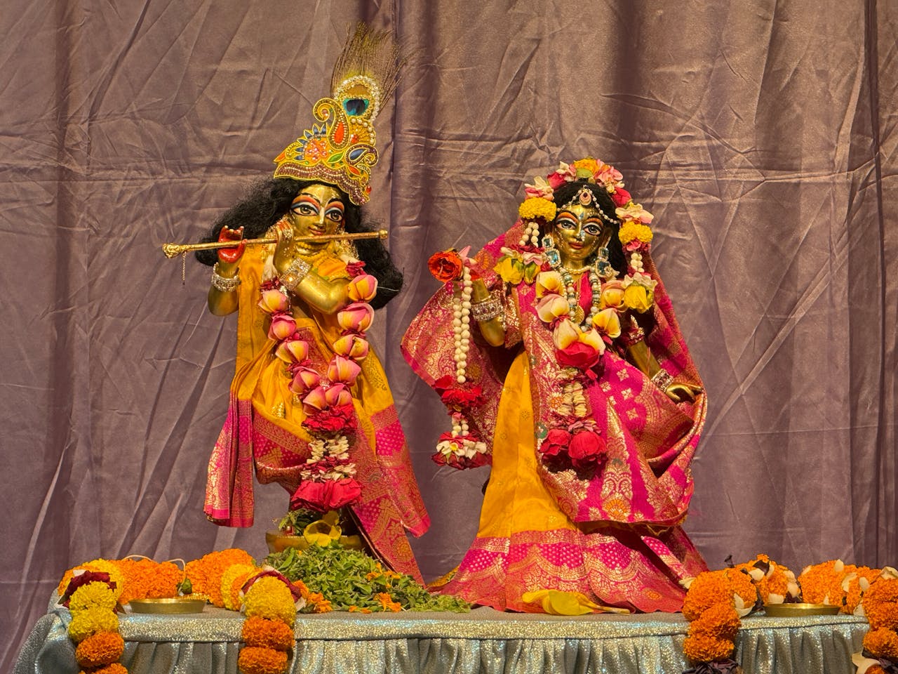 Vibrant statues of Hindu deities adorned with flowers, embodying cultural and spiritual significance.